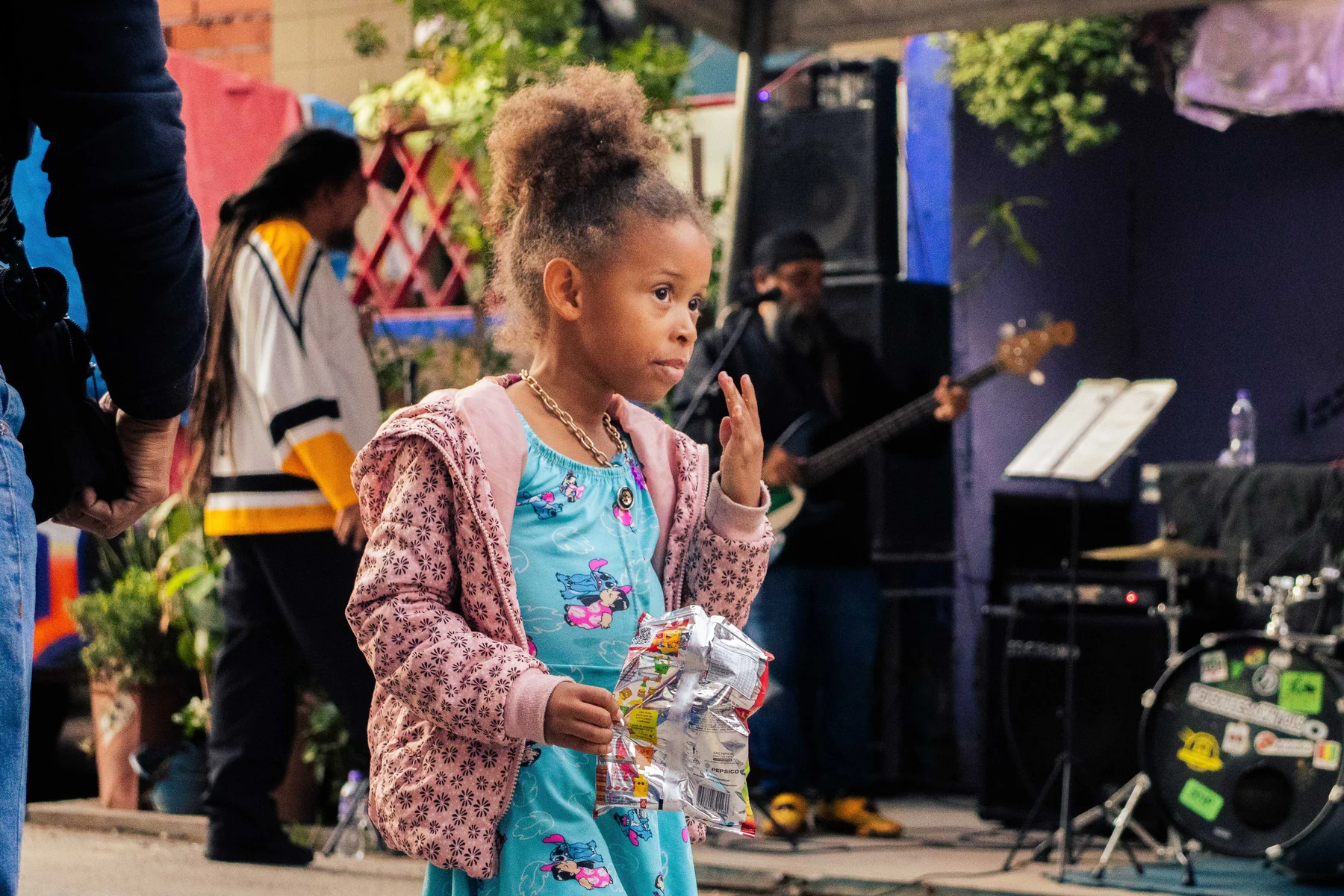 Criança acompanha apresentação musical com outros participantes
